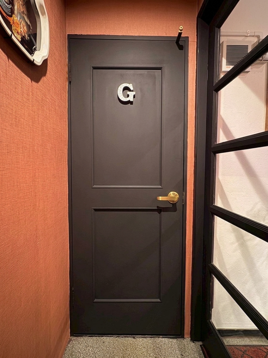  階段を上がると正面が御手洗いで、右手が店内入口です。